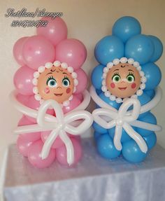 two balloons with faces on them are sitting on a table next to each other,