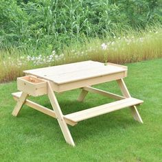 a wooden picnic table sitting in the grass