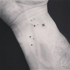 a black and white photo of a person's wrist with small stars on it