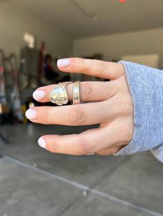 a woman's hand with two rings on her fingers and one ring in the middle