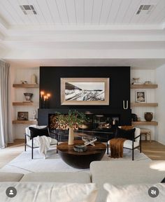 a living room filled with furniture and a fire place under a painting on the wall