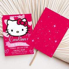 a pink hello kitty birthday party card on top of an open book with matchesticks