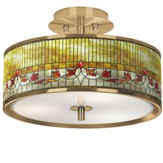 a semi flush light fixture with stained glass and flowers on the drum, in an antique brass finish