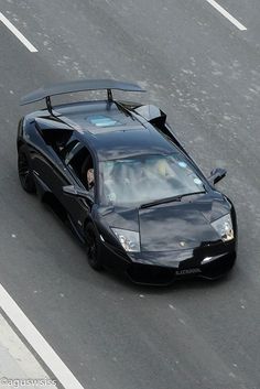 a black sports car driving down the street