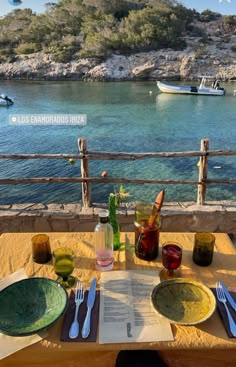 the table is set for two on the deck overlooking the water and boats in the bay