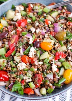 a salad with lentils, tomatoes, cucumbers and feta cheese