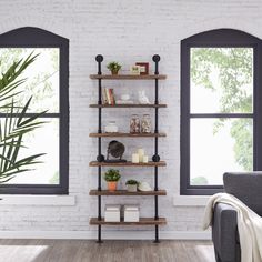 a living room with two windows and a book shelf on the wall next to a couch