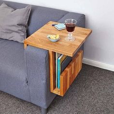 a couch with a wooden table on top of it next to a glass of wine