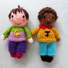 two small knitted dolls sitting next to each other