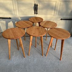 four wooden tables sitting in front of a garage door