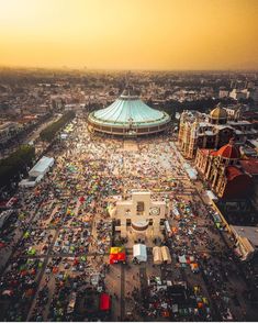 an aerial view of a fairground with tents and cars in the foreground at sunset