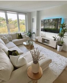 a living room filled with furniture and a large flat screen tv mounted to the wall