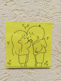 a drawing of two people kissing each other on a yellow piece of paper with hearts