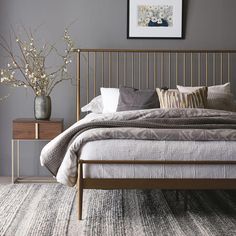 a bedroom with grey walls and gold bed frame