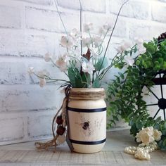 a vase with flowers in it sitting on a table next to a potted plant