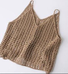 a crochet top is shown on a white surface with the bottom half open