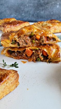 three pastries stacked on top of each other with vegetables and meat in the middle