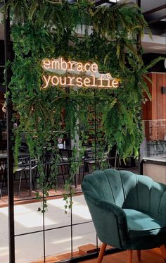 a green chair sitting in front of a sign that says embrace yourself