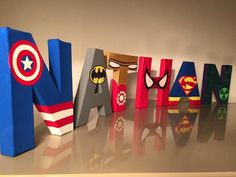 the letters are made out of wood and have superhero logos on them