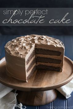 a chocolate cake on a wooden plate with the slice cut out and ready to be eaten