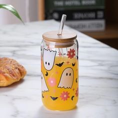 a glass jar sitting on top of a counter next to a pastry