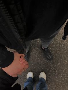 two people standing next to each other with their hands together