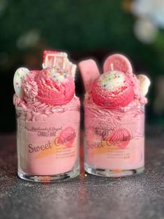 two pink ice creams in small glass containers with sprinkles on top