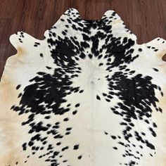 black and white cowhide rug on wooden floor