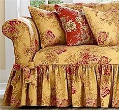 the couch is covered in red and gold floral fabric with ruffles on it