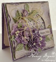 a close up of a card with purple flowers and a tag on the bottom that says happy new year