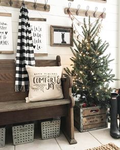 a wooden bench sitting next to a christmas tree in a room with pictures on the wall