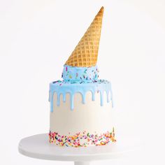 an ice cream cone cake with sprinkles and blue icing on top