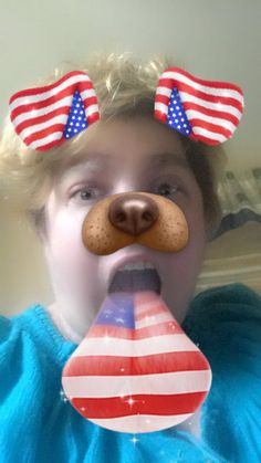 a young boy with an american flag nose piece on his tongue, making a funny face