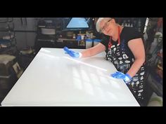 an older woman cleaning a table with blue gloves