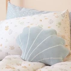 a close up of pillows on a bed with sea shells and stars in the background