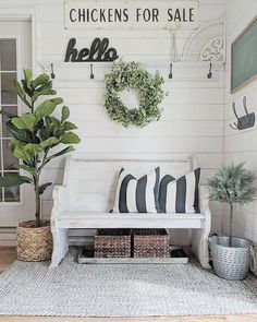 a white couch sitting in front of a window next to a potted plant