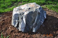 a large rock sitting on top of a pile of dirt