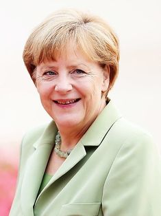 a woman in a green suit smiling at the camera