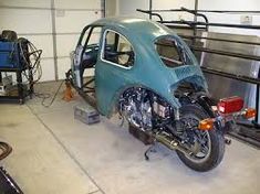 a motorcycle parked inside of a garage next to a car