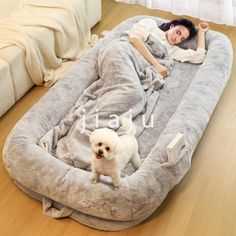 a woman laying on top of a dog bed