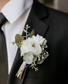 a man in a suit and tie with a boutonniere on his lapel