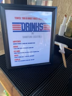 a framed poster on top of a table with drinks in front of it that reads drinkin's