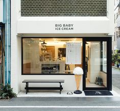 a big baby ice cream store front with an ice cream cone on the bench outside