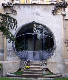 an old building with a circular window and steps leading up to the front door is shown