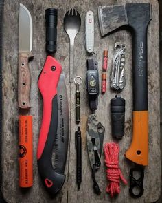 an assortment of tools are laid out on a wooden tray with handles and knives in it