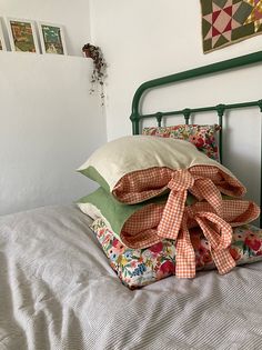 a bed with four pillows on top of it and some pictures above the headboard