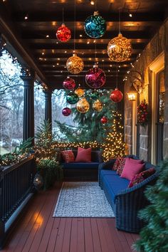 a porch decorated for christmas with ornaments and lights hanging from it's ceiling above the couch