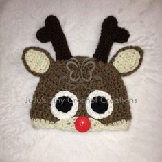 a crocheted reindeer hat with big eyes and nose is shown on a white blanket