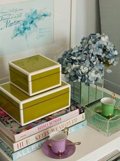 a stack of books sitting on top of a table next to a cup and saucer