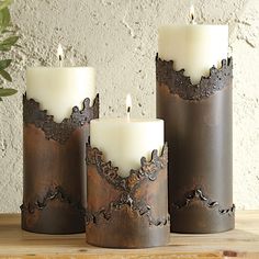 three candles sitting on top of a wooden table